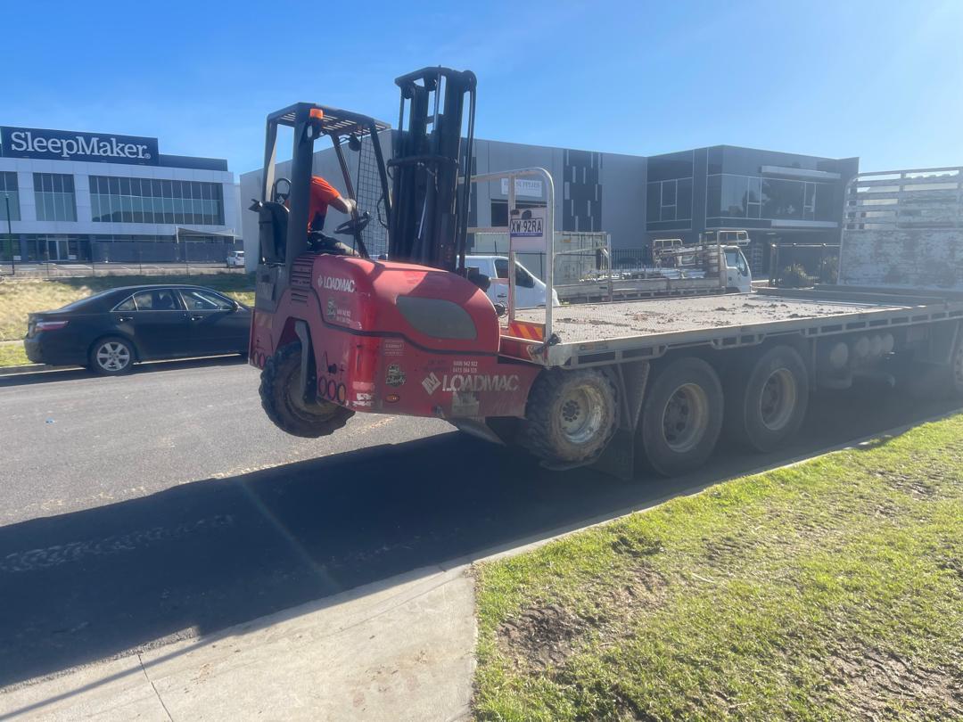 Truck-mounted all-terrain forklift unloading on an industrial site in Melbourne