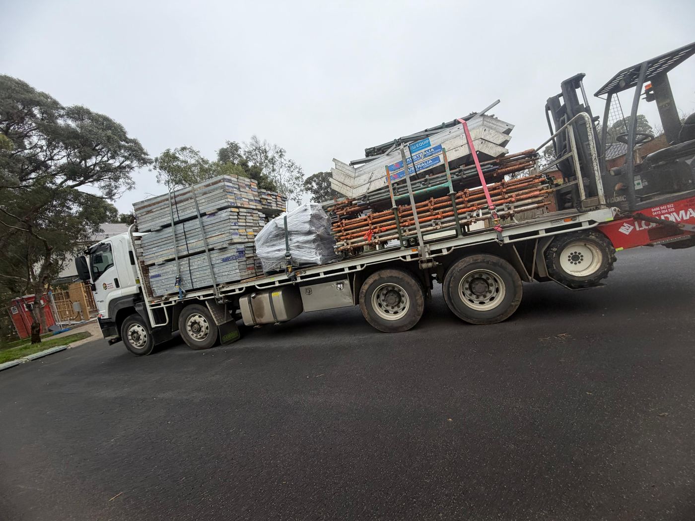 Liberty Transport truck with Loadmac rear-mounted forklift delivering scaffolding to Melbourne construction site
